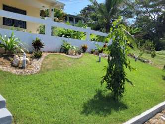 Tropical garden and lawn with white fence rental house Puerto Pilón Colon Panama
