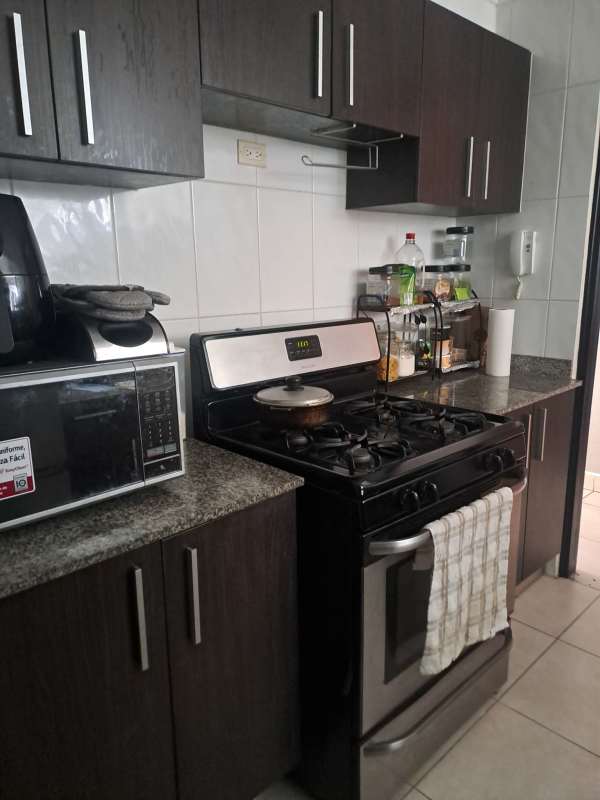 Modern kitchen with granite counters, appliances, large window at PH El Mare 600 Edison Park Panama