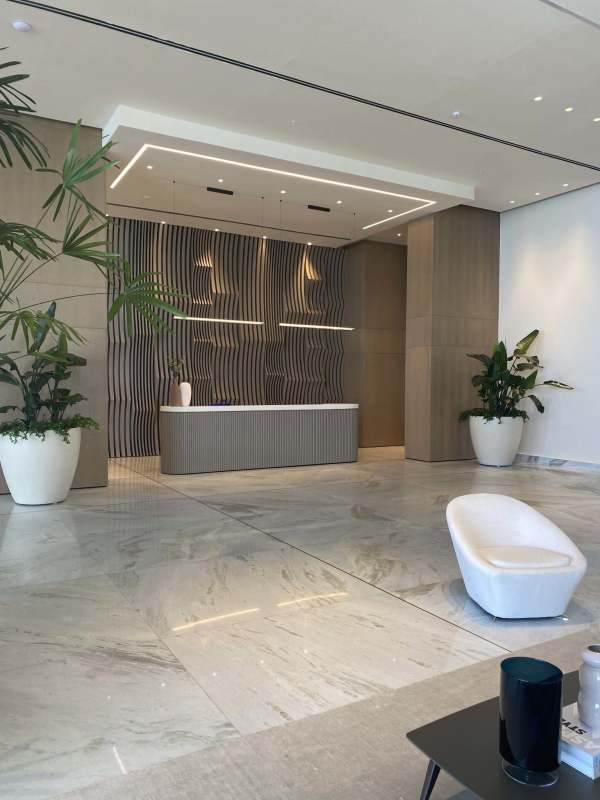 Reception area with decorative accent wall, white lounge chairs and marble floors in luxury PH Sea Point Panama City