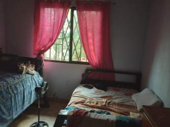 Bedroom twin beds pink curtains window affordable rural house sale Panama