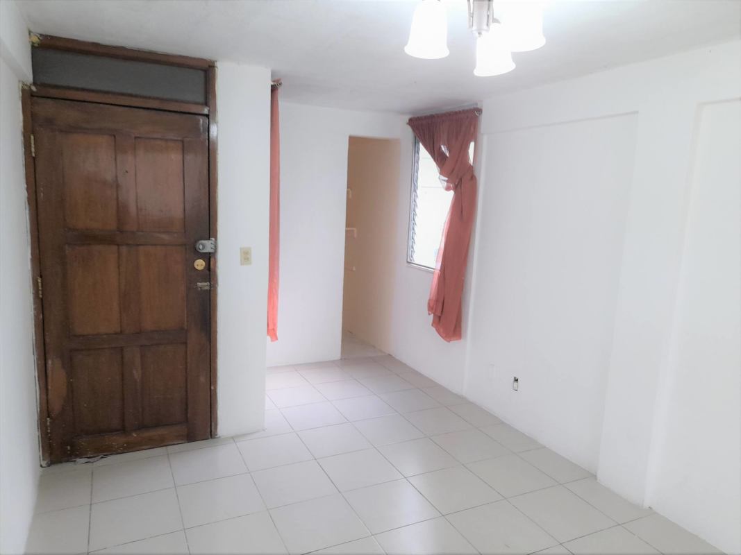 Simple entryway and mini living area with tiled floors and wooden door at Villa Cáceres Panama
