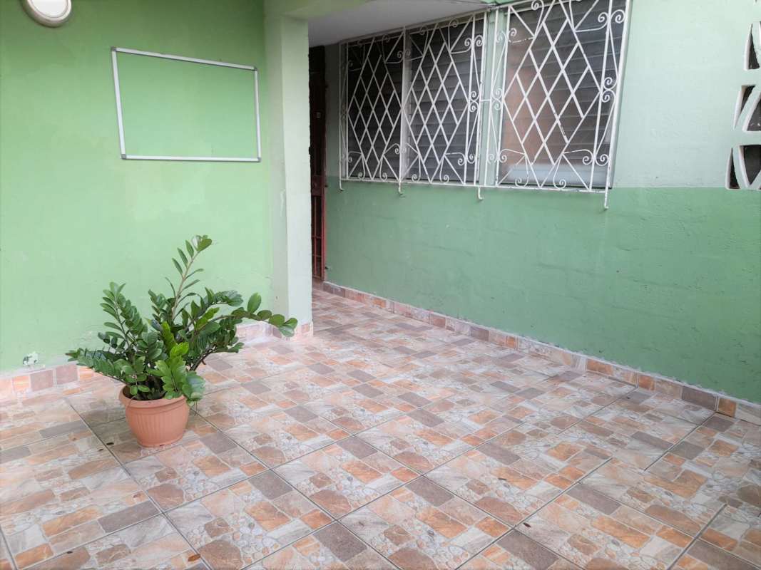 Small outdoor patio space with tile floor and security window in Villa Cáceres Panama