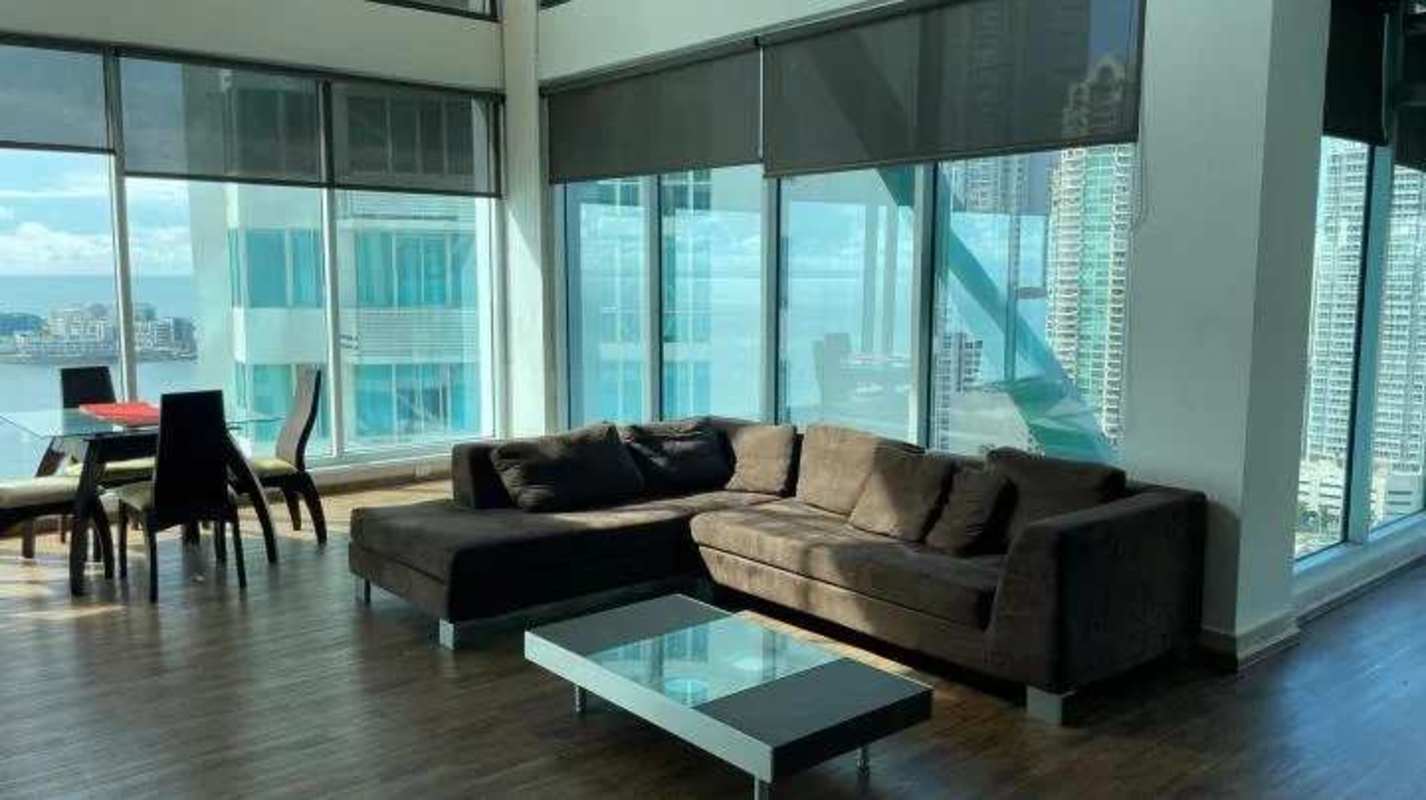 Modern open concept living kitchen with mezzanine and floor-to-ceiling ocean views in Punta Pacifica Panama