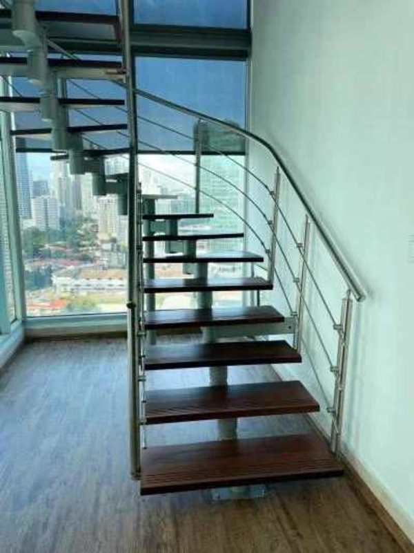 Spiral staircase and panoramic windows with skyline view inside loft PH Loft 41 Punta Pacifica Panama