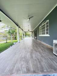 Covered porch with tiled floor, ceiling fans, overlooking garden in Panama Pacifico