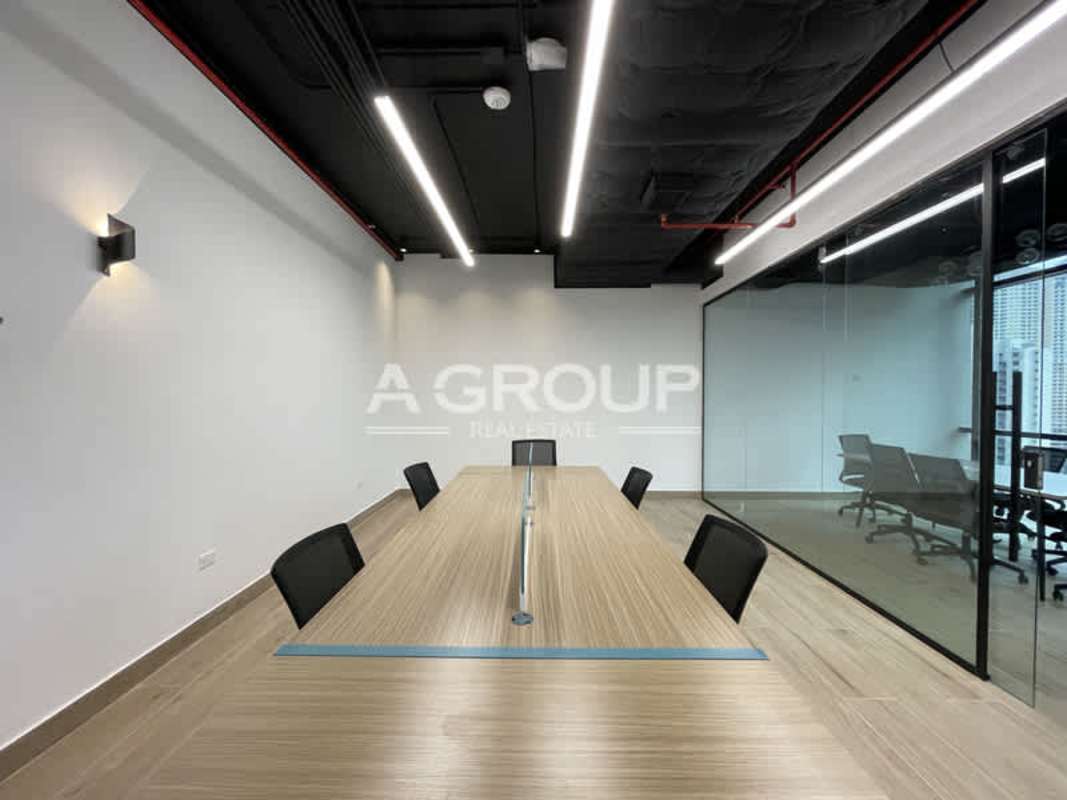 Conference room with long wood table, modern black chairs, glass walls in premium Panama City office building