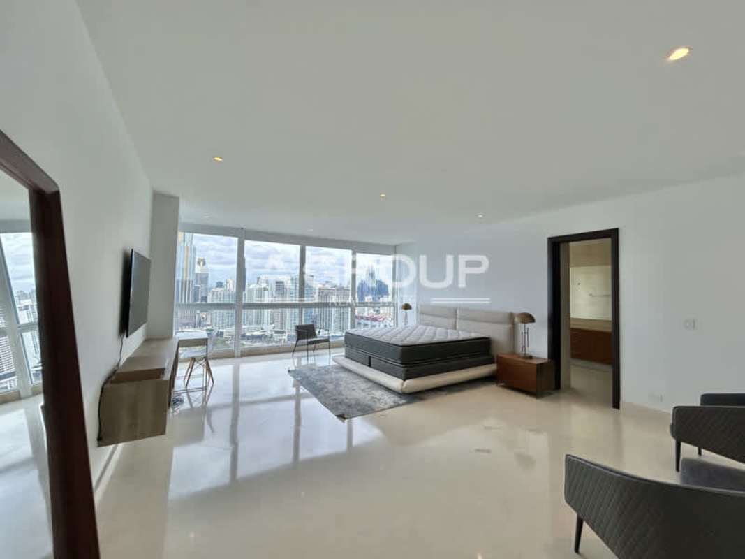 Primary bedroom floor-to-ceiling windows city skyline view The Point Panama