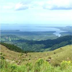 Lush green valley with water body and surrounding mountains at Cerro Campana Capira Panama