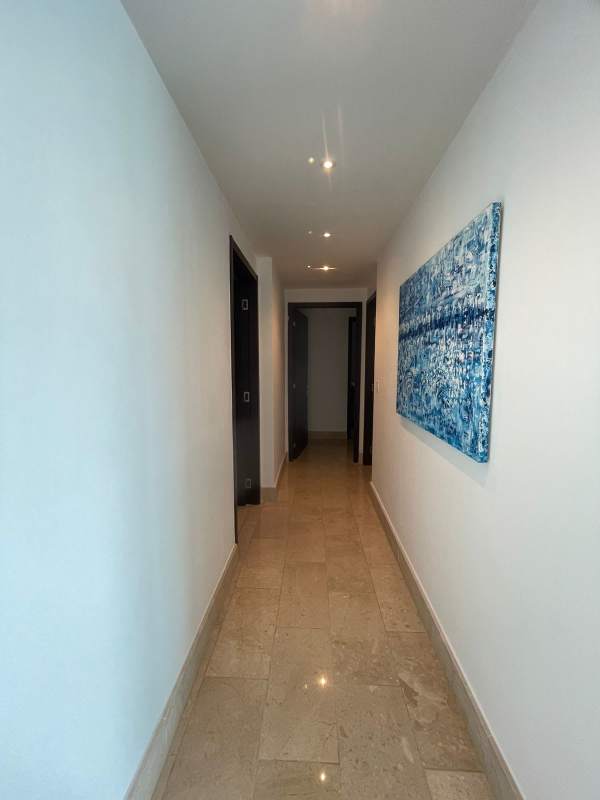 Long modern condo hallway with tile floors recessed lighting artwork Grand Tower Panama