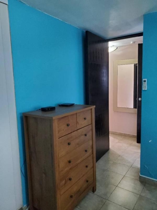 Bedroom with blue accent wall, chest of drawers, tile floor in PH Cosmopolitan Panama City
