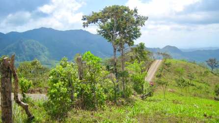 Green rolling hills and distant mountains under blue sky Panama countryside land