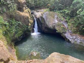 Small natural waterfall with clear pool and lush greenery on mountain property near El Valle de Antón