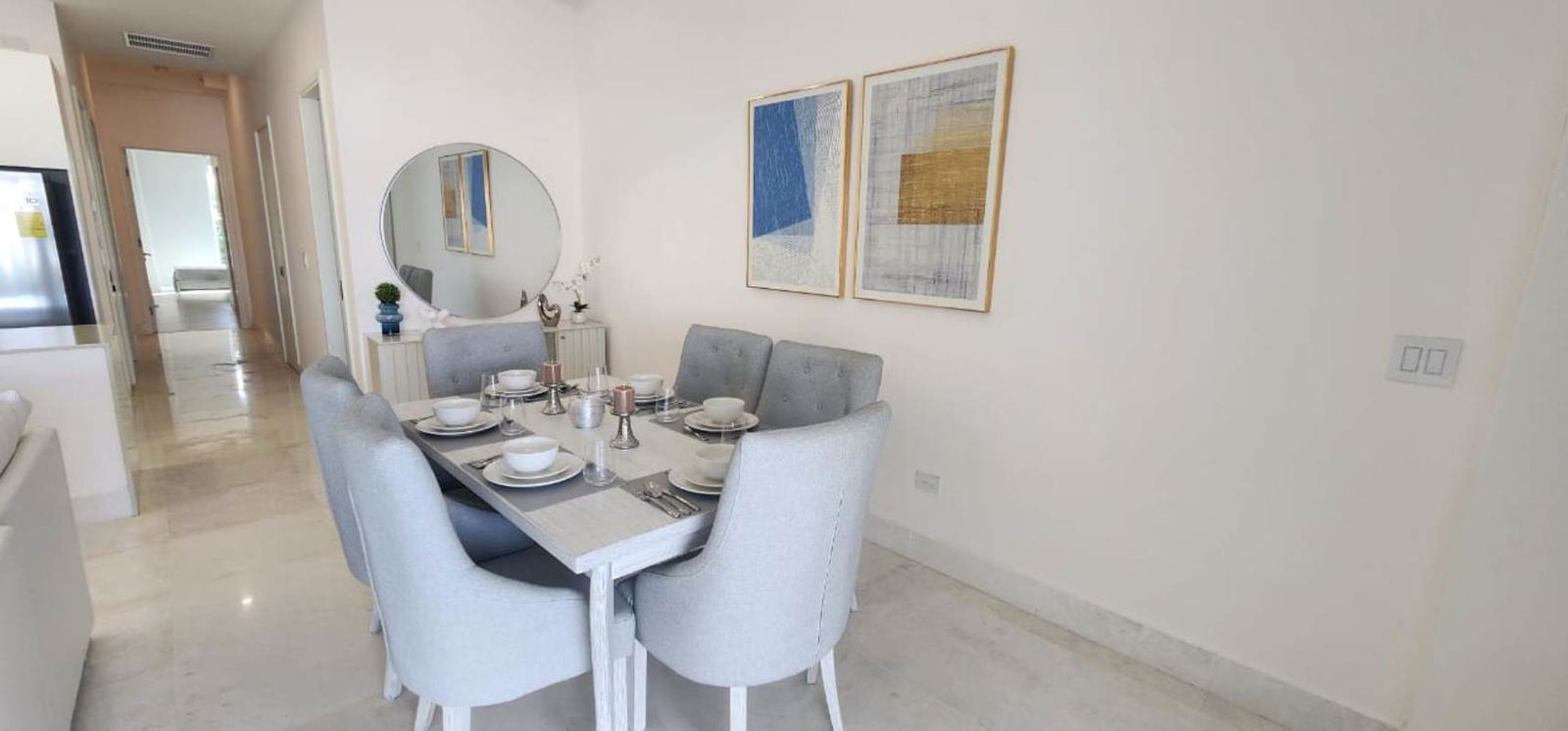 Dining area with mirror, modern furniture and art at Ocean Reef Residence in Panama City