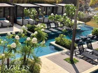 Luxury swimming pool area with lounge chairs and lush landscaping at Punta Caelo San Carlos Panama