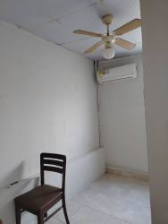 Small bathroom with green accent tile, toilet, shower and brown door La Chorrera Panama