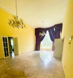 Vaulted ceiling living room with chandeliers, large windows, tiled floors at Boquete home