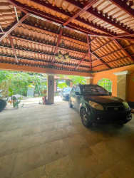Covered carport with ceiling fan, tiled roof, next to lush garden Boquete