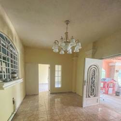 Entryway inside Boquete house with chandelier, arched window and ornate door