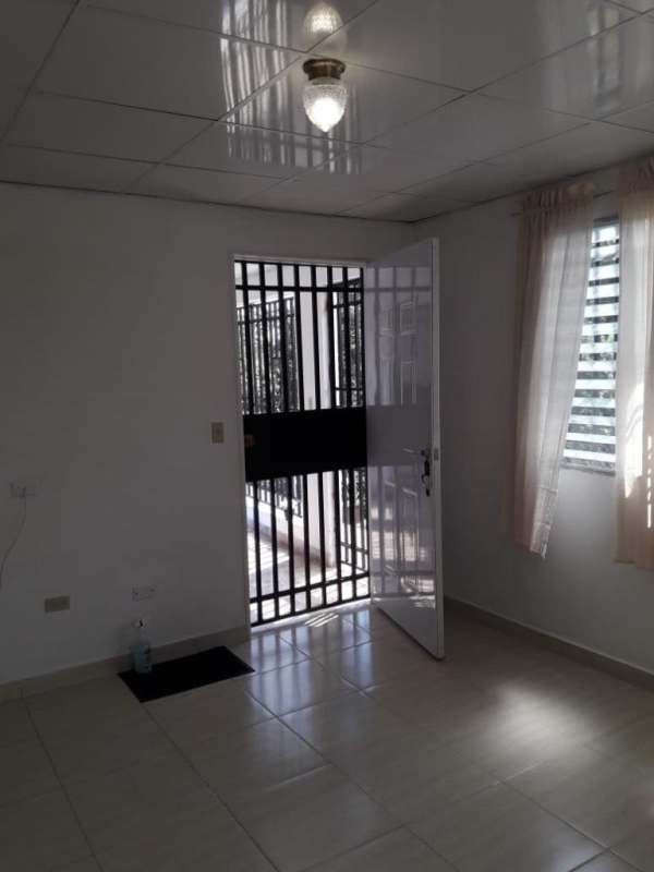 Small living room and entry area with metal security door in Villa Serena Las Cumbres