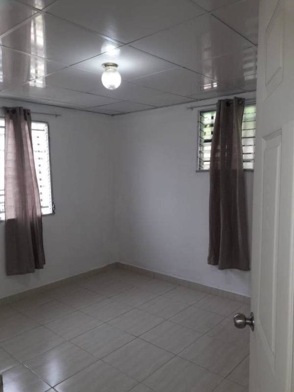 Empty minimalist bedroom with tiled floor and windows in Villa Serena Las Cumbres Panama City