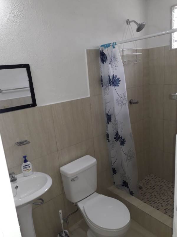 Bedroom with tiled floor, two curtained windows and white walls at Villa Serena Las Cumbres