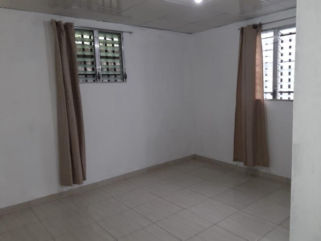 Empty bedroom with two windows, tiled floor, ceiling light in Villa Serena Panama City