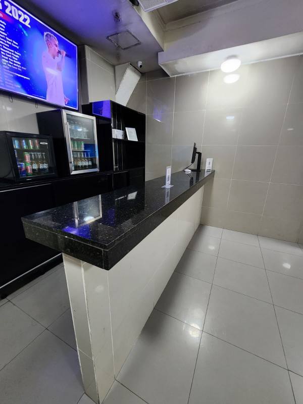 Lobby reception counter with beverage cooler and wall-mounted TV in restaurant Avenida Justo Arosemena Panama City