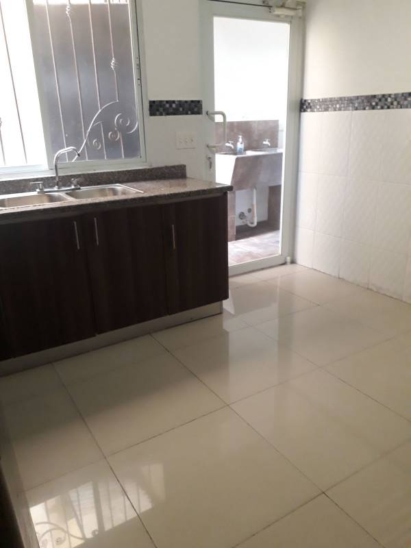 Kitchen dark wood cabinets granite countertops double sink in Altavista Residences El Bosque Panama