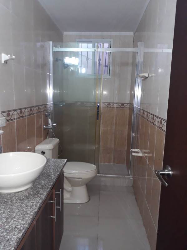 Large master bedroom tile floor dark wood furniture in Altavista Residences Panama