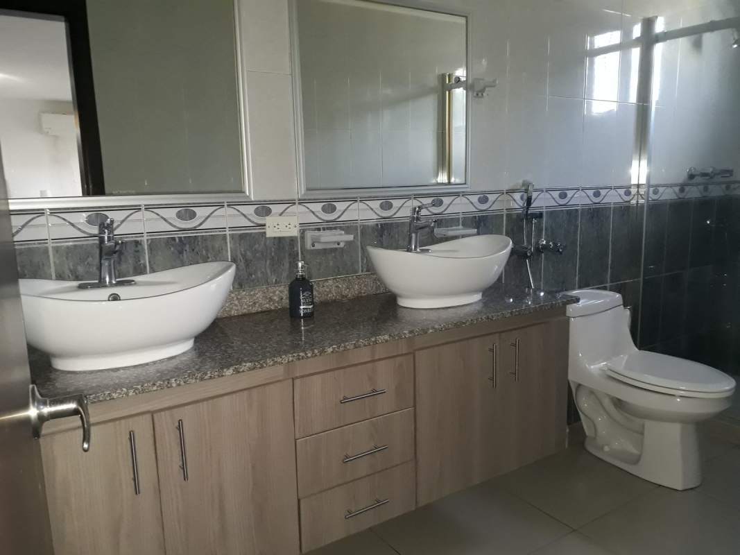 Modern bathroom double sinks granite countertop large mirror in Altavista Residences Panama City