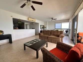 Bright living room with panoramic ocean front windows and beach views at PH Biltmore Playa Malibú Panama