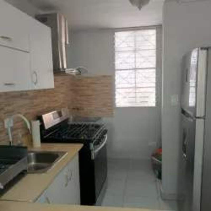 Bright bedroom with tiled floor, wood bed frame in apartment Panama Rio Abajo