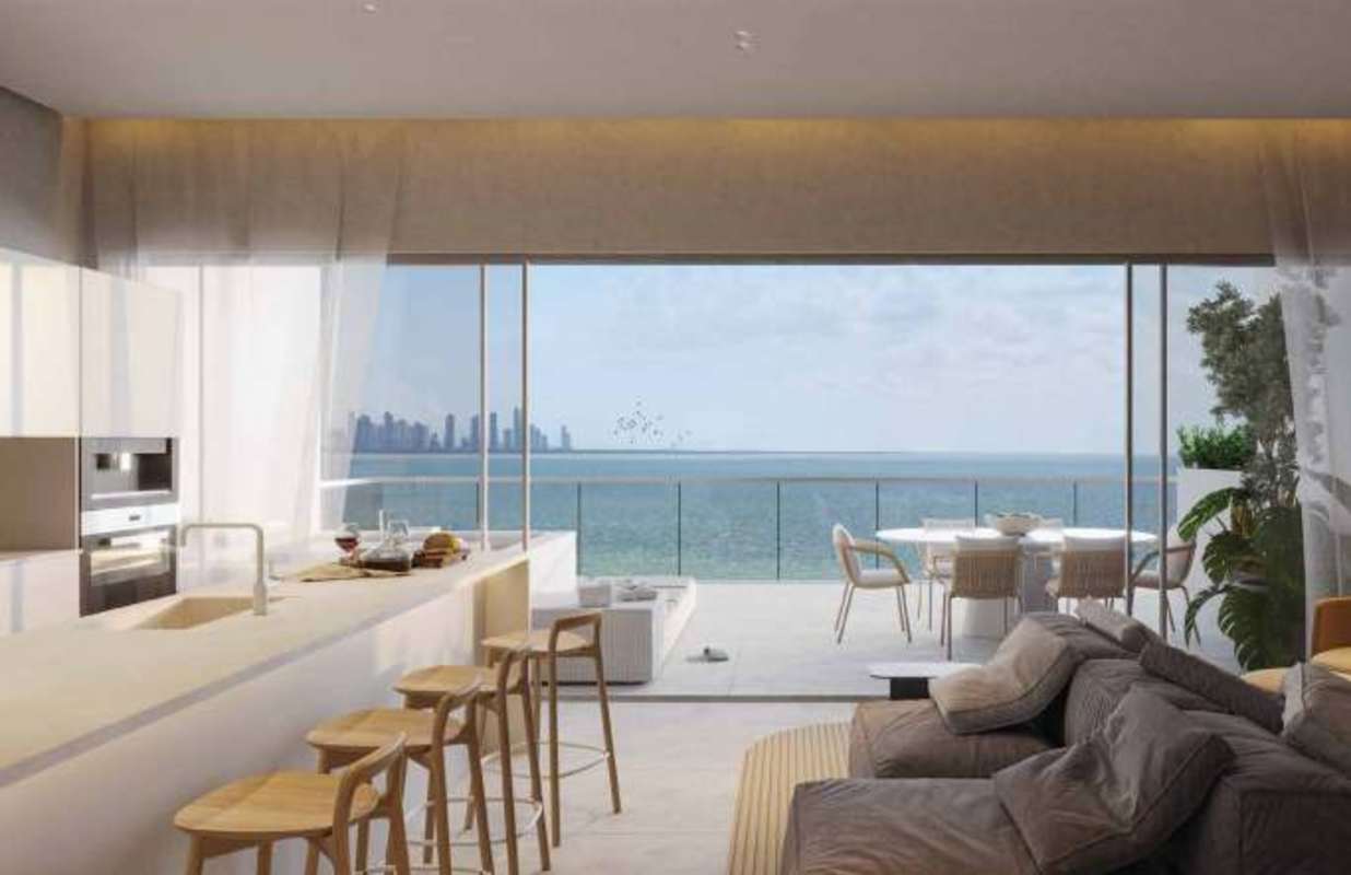 Living room with floor-to-ceiling sliding doors opening to private terrace with ocean view at Ocean Reef Panama City