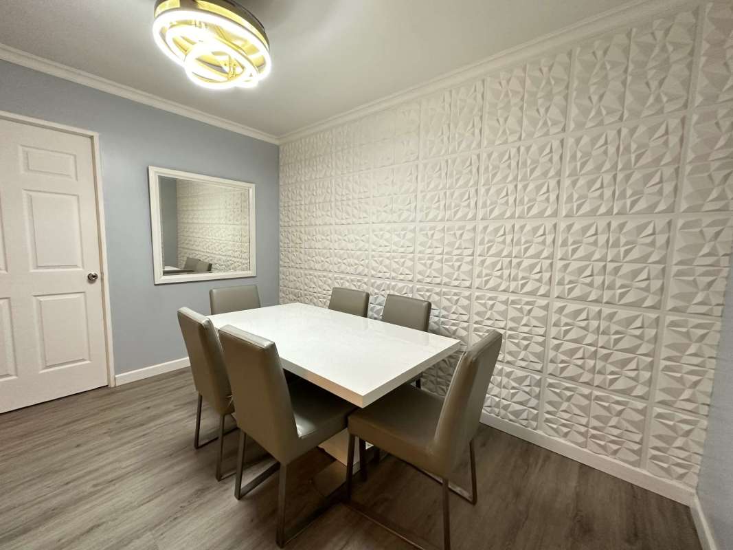 Dining space with textured accent wall, elegant lighting and mirror decor in PH Bella Vista Place Panama
