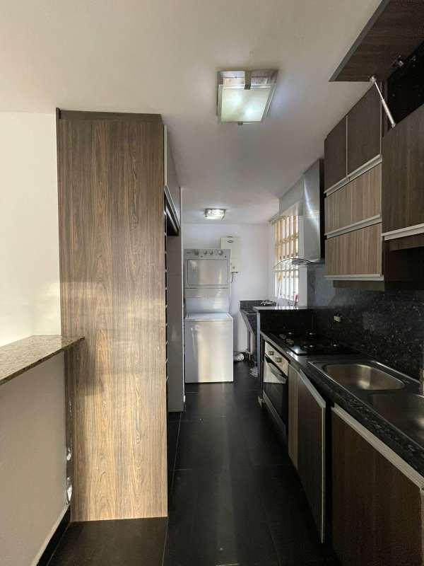 Modern kitchen with granite counters, wood cabinets PH Torres de Toscana Transístmica Panama