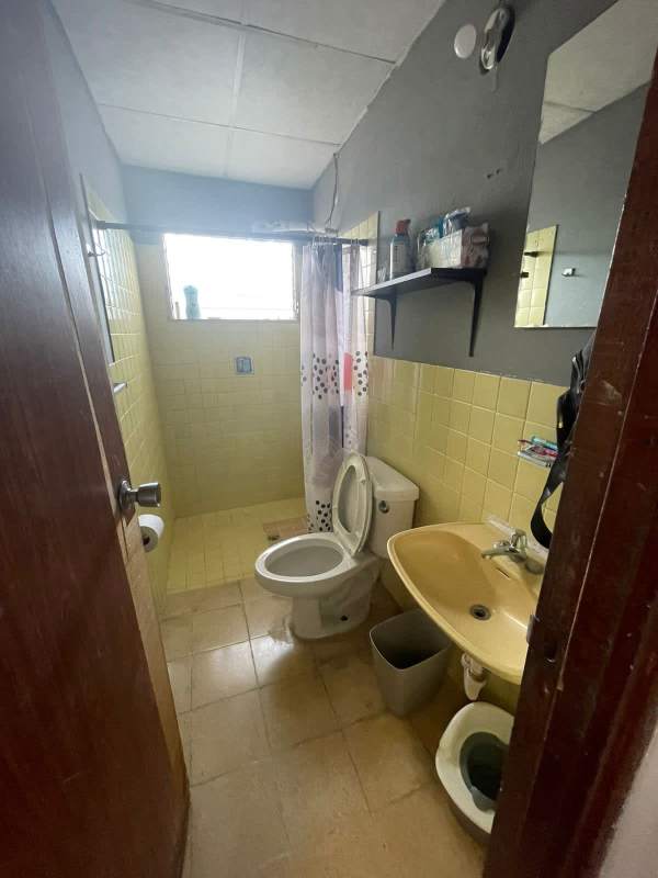 Bathroom with shower area, sink, teal walls, and laundry baskets in Condado del Rey