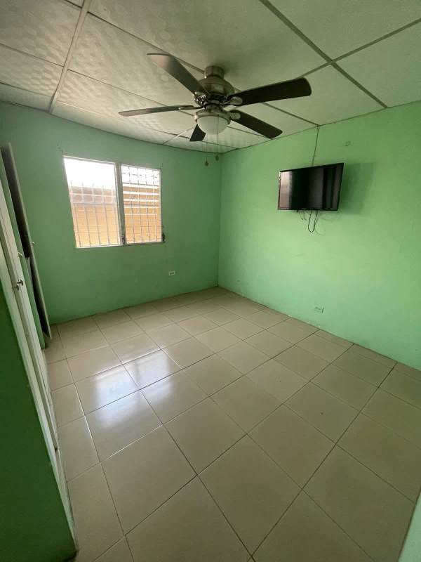 Bedroom with green walls, ceiling fan and wall TV for rent in Condado del Rey Panama
