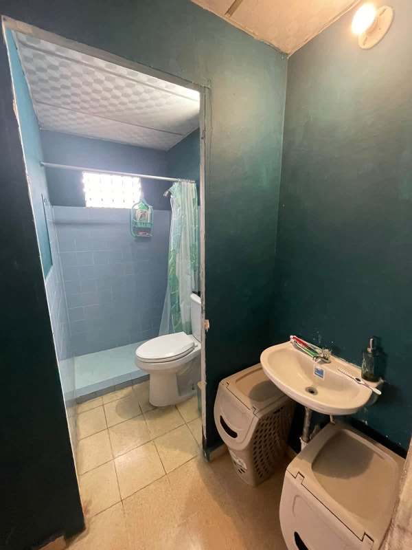 Bathroom with walk-in shower, vanity sink, teal walls in Linda Vista Condado del Rey house