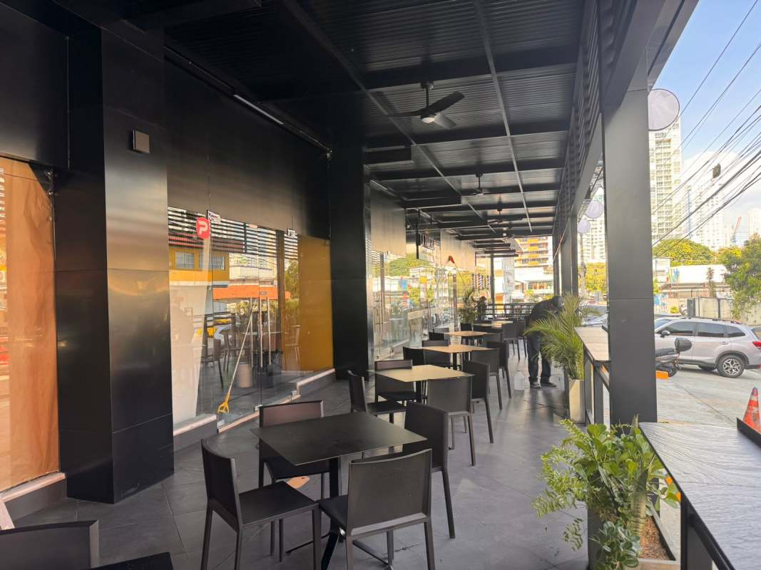 Covered outdoor terrace with black tables chairs overlooking city street Plaza 68 San Francisco