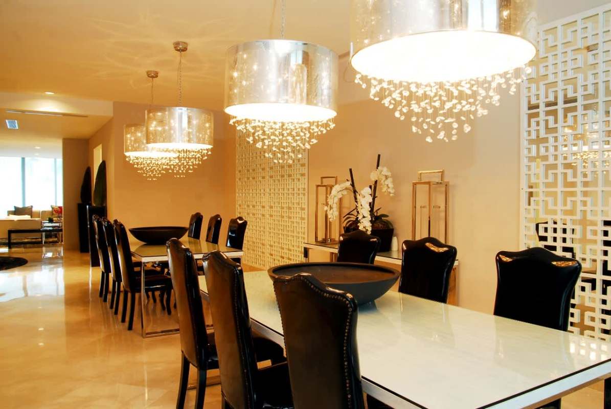 Modern dining room with crystal chandeliers, glass top table and mirrored decor in PH Miradores Punta Paitilla Panama