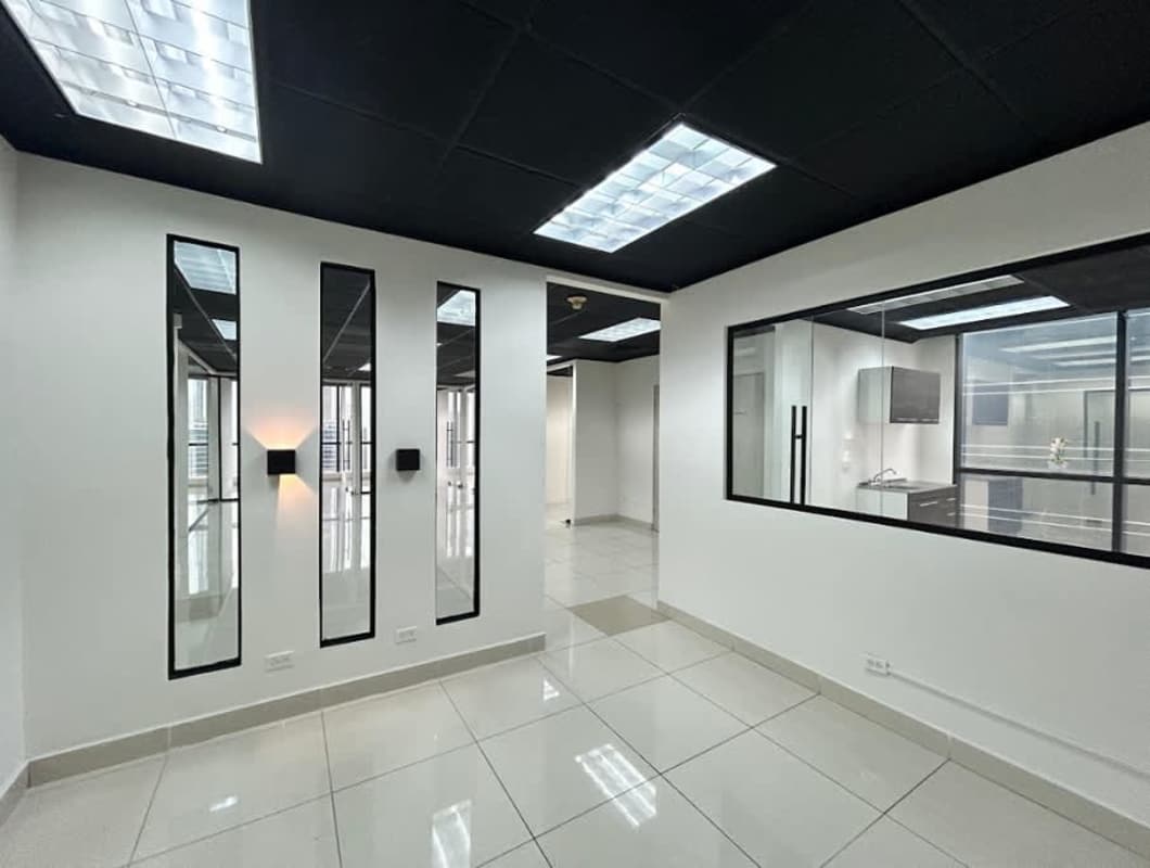 Modern office in Panama City with tiled flooring glass partitions black drop ceiling Plaza Banco General