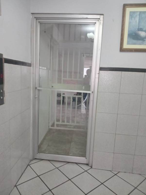 Interior hallway with glass elevator door and tiled walls Centro Ejecutivo 12 de Octubre Panama