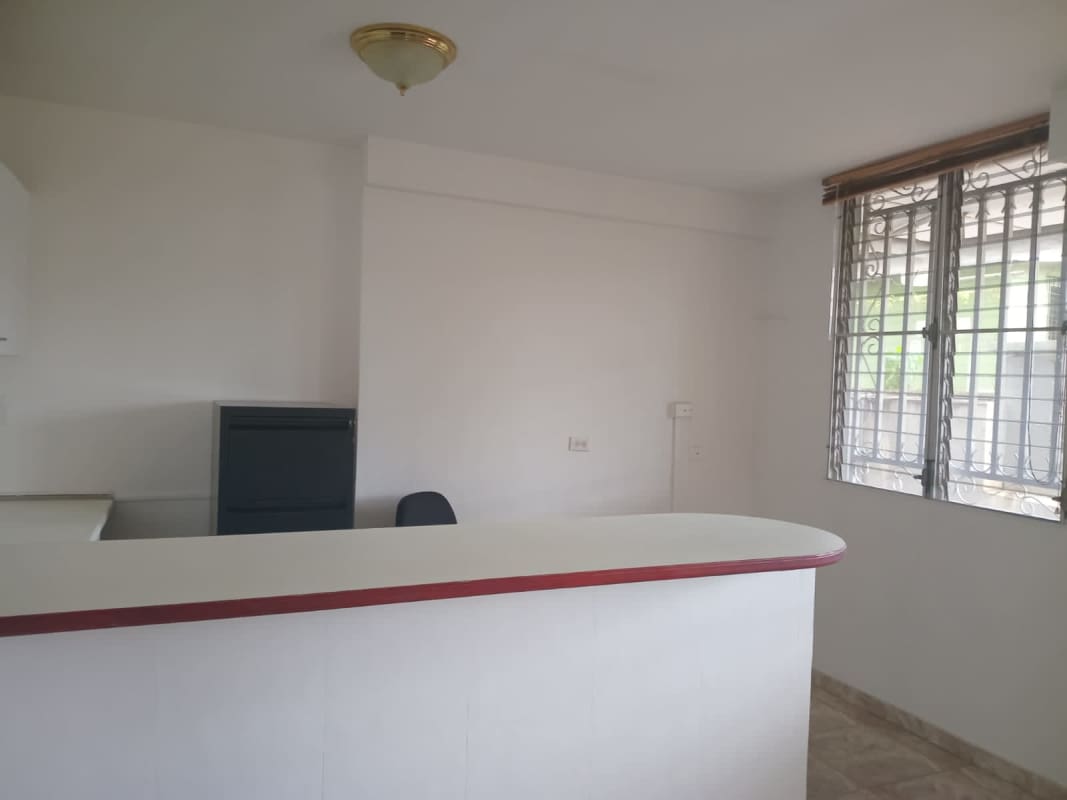 Small kitchenette with curved breakfast bar, white cabinetry, tile flooring, window Centro Ejecutivo 12 de Octubre Panama