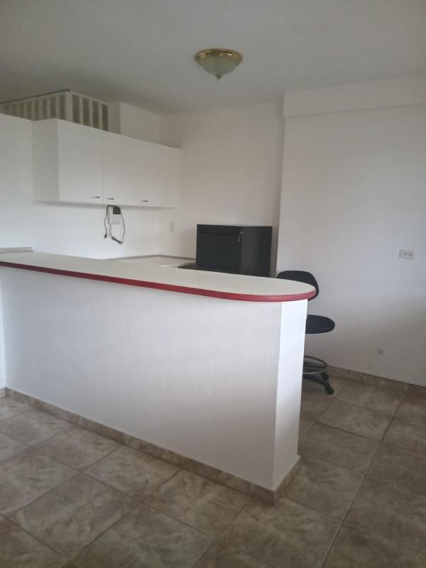Small office meeting room with round wooden table, three mesh chairs, window with blinds in 12 de Octubre Panama