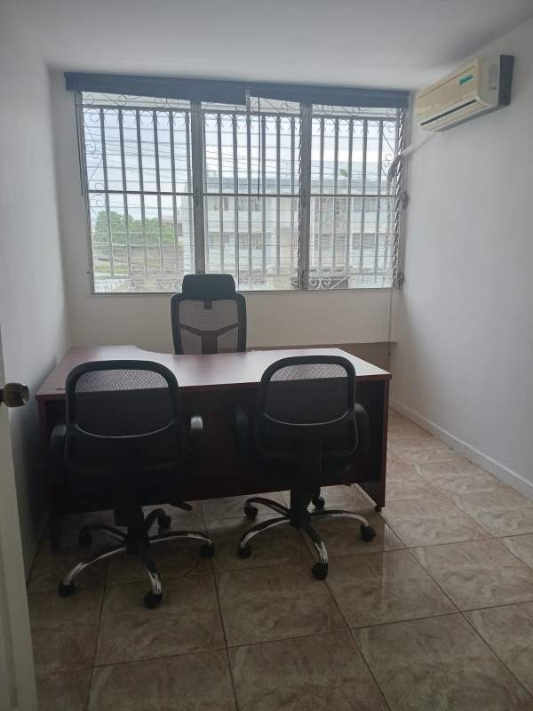 Compact bathroom with pedestal sink, toilet, mirror, tiled walls office building Panama City