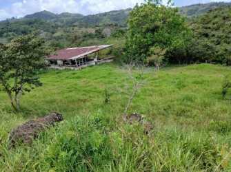House with red roof surrounded by open country pasture in Ollas Abajo Chorrera farmland Panama