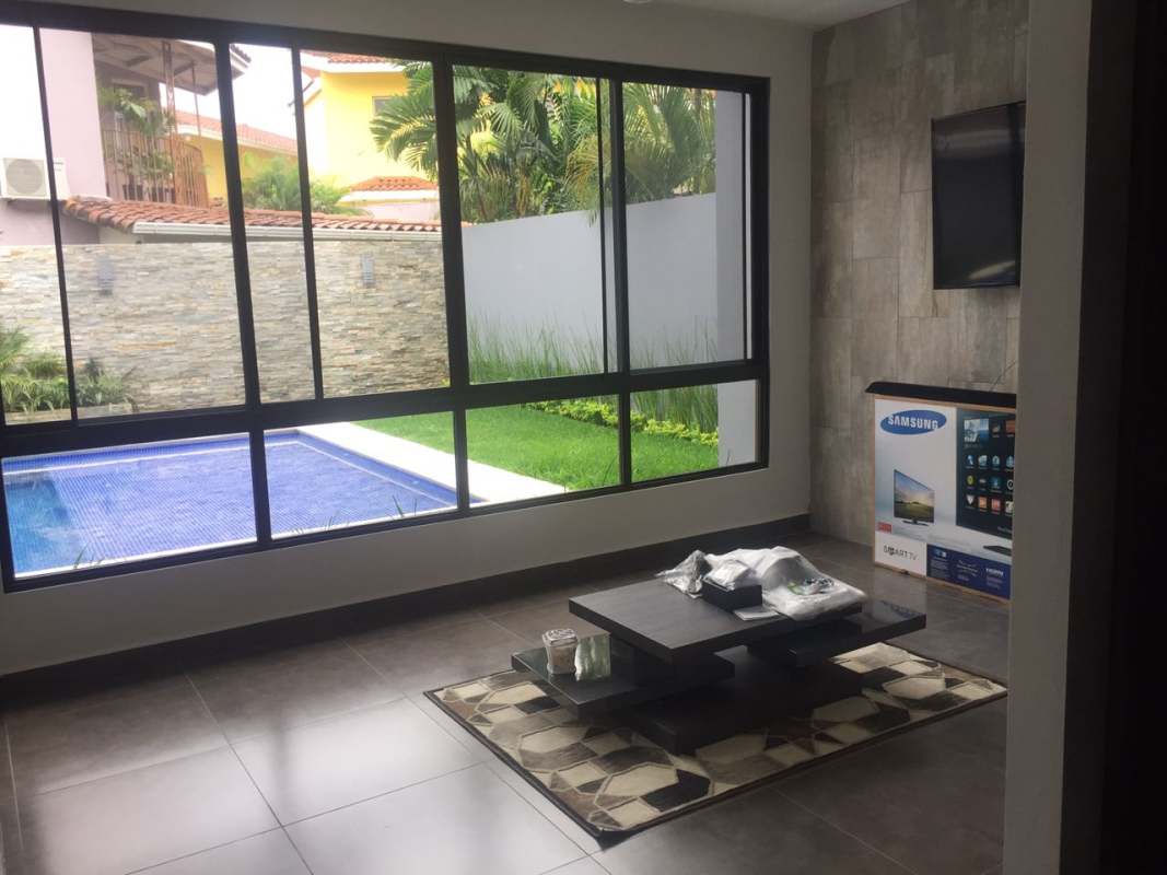 Open-concept living space with sofa and pool view in luxury house Altos de Panamá Panama
