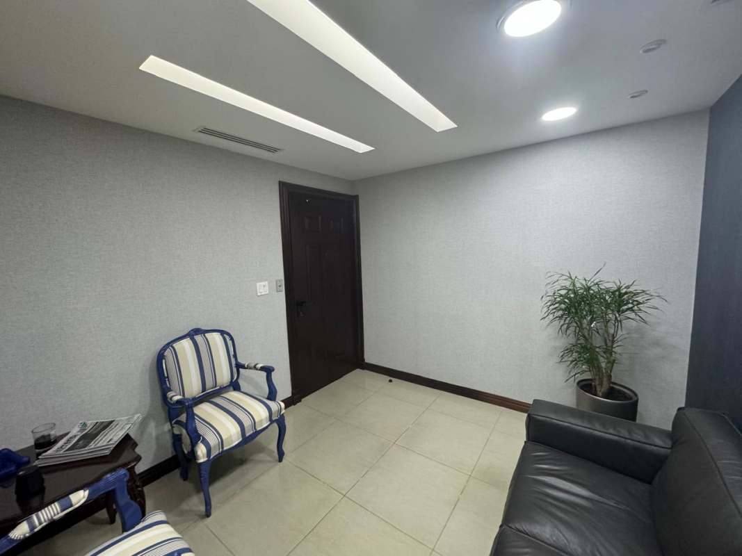 Minimalist waiting room with striped chairs and potted plant in Obarrio Business Tower Panama