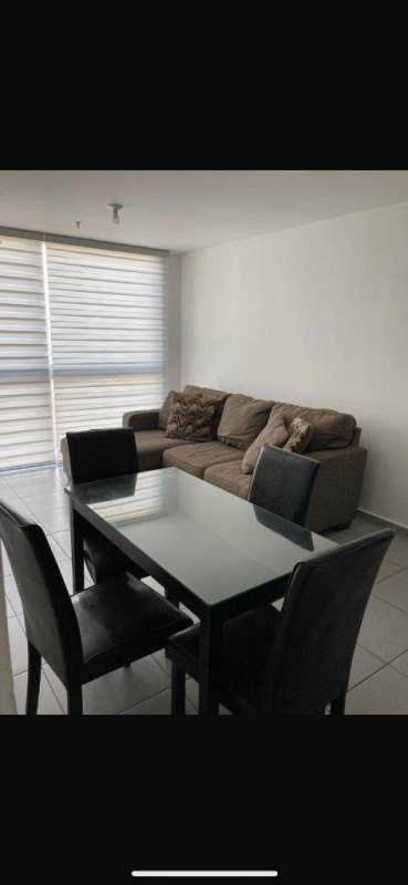 Open concept living dining area with sofa dining table large window PH Aviñon Towers Panama