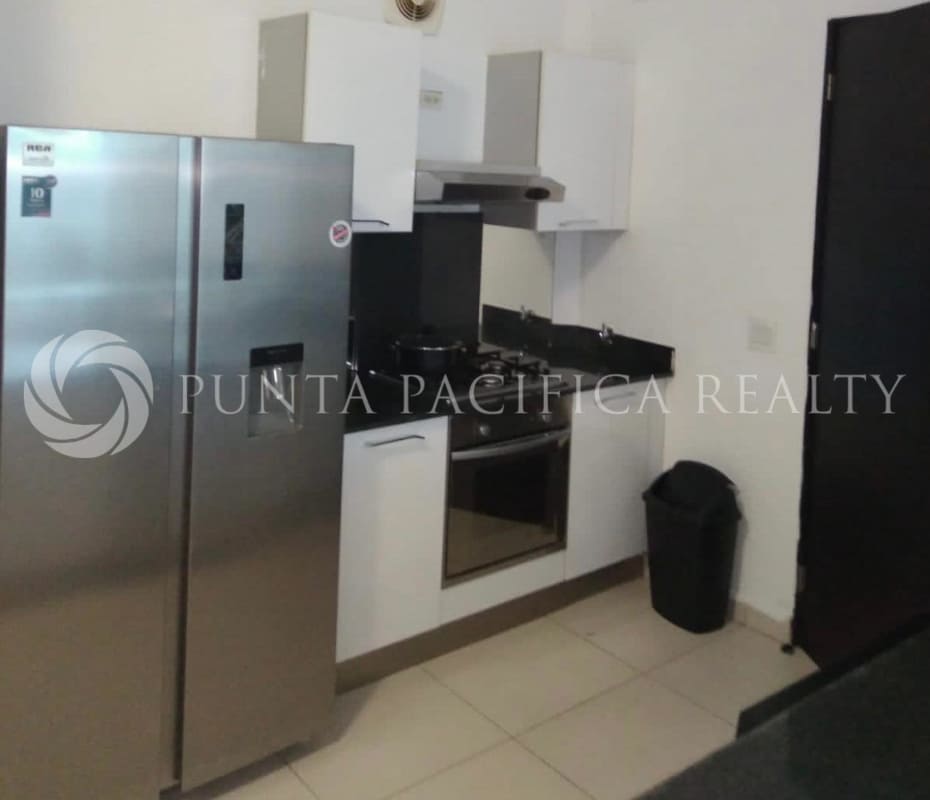 Kitchen with stainless refrigerator, gas stove, black countertops and modern cabinetry in PH Destiny Panama apartment